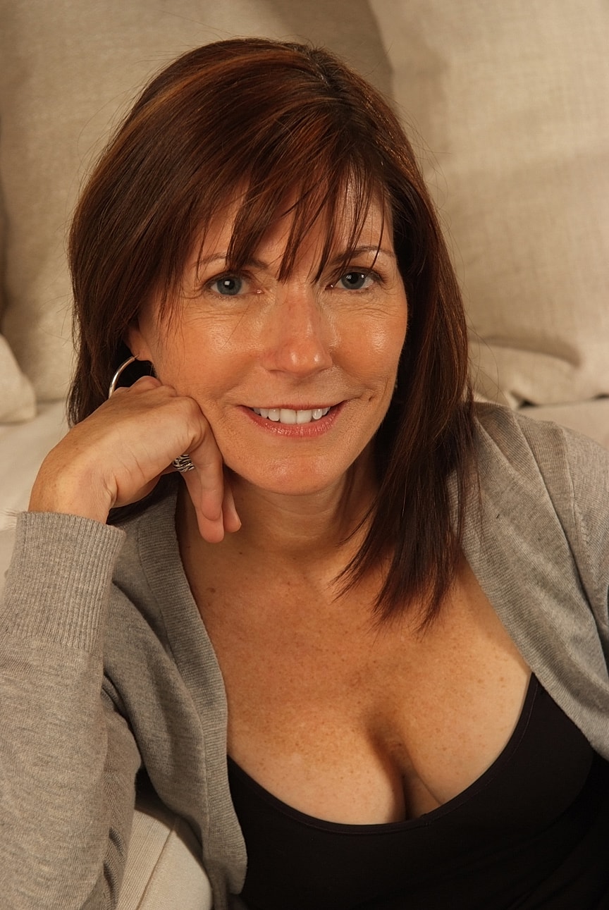 Smiling woman posing on a couch.