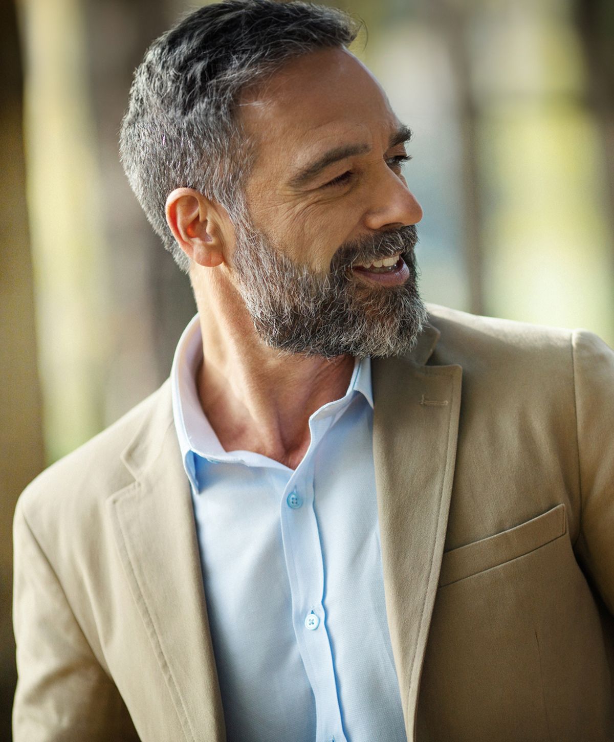 Smiling man in a light suit, enjoying his moment.
