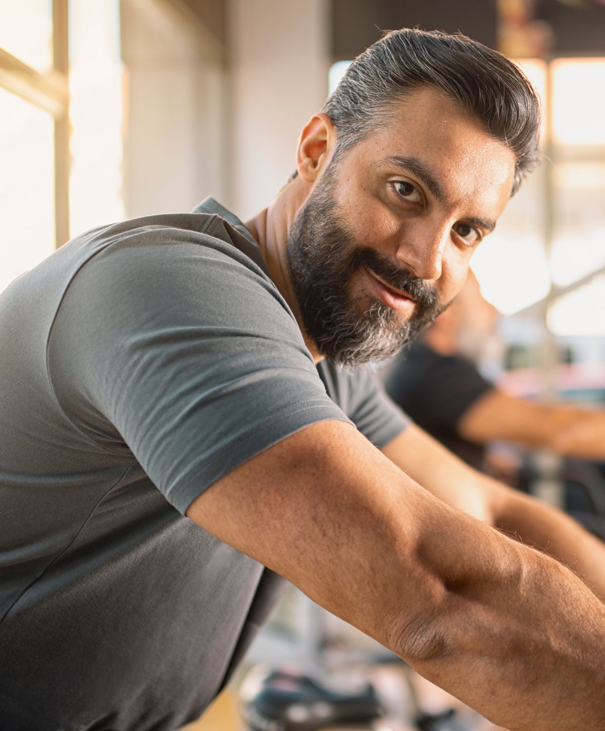 Man smiling at gym equipment indoors