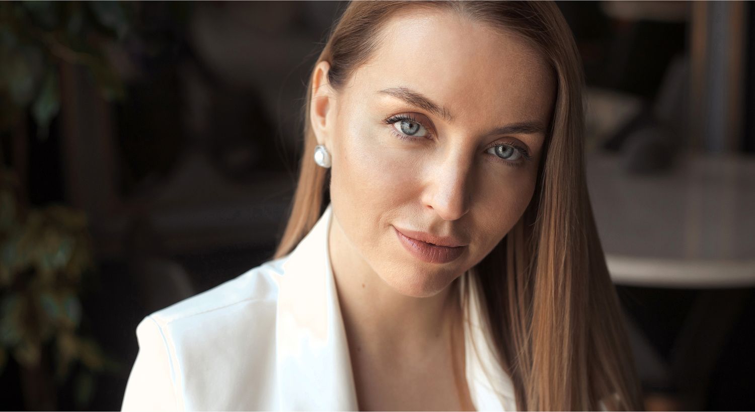 Woman with blue eyes and elegant hairstyle.
