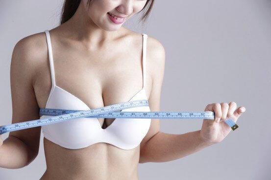 female model measuring breasts