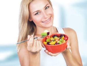 Woman eating a bowl of fruit