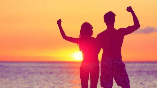 Woman and man on a beach at sunset