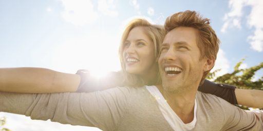 a happy couple smiling outdoors