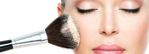 woman applying powder makeup